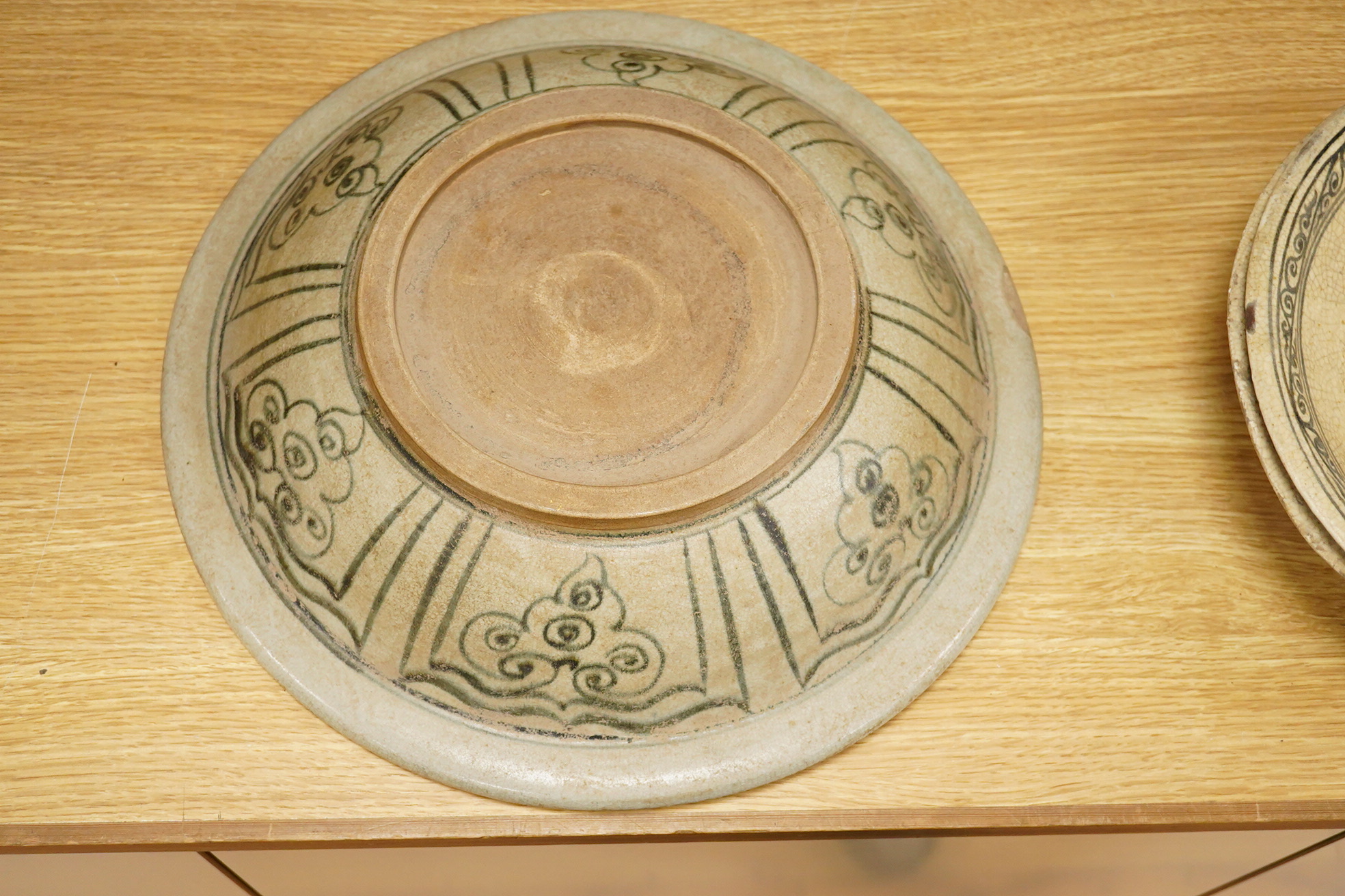 A group of three Thai underglaze blue or black crackle glaze dishes, two decorated with fish, largest 38cm in diameter